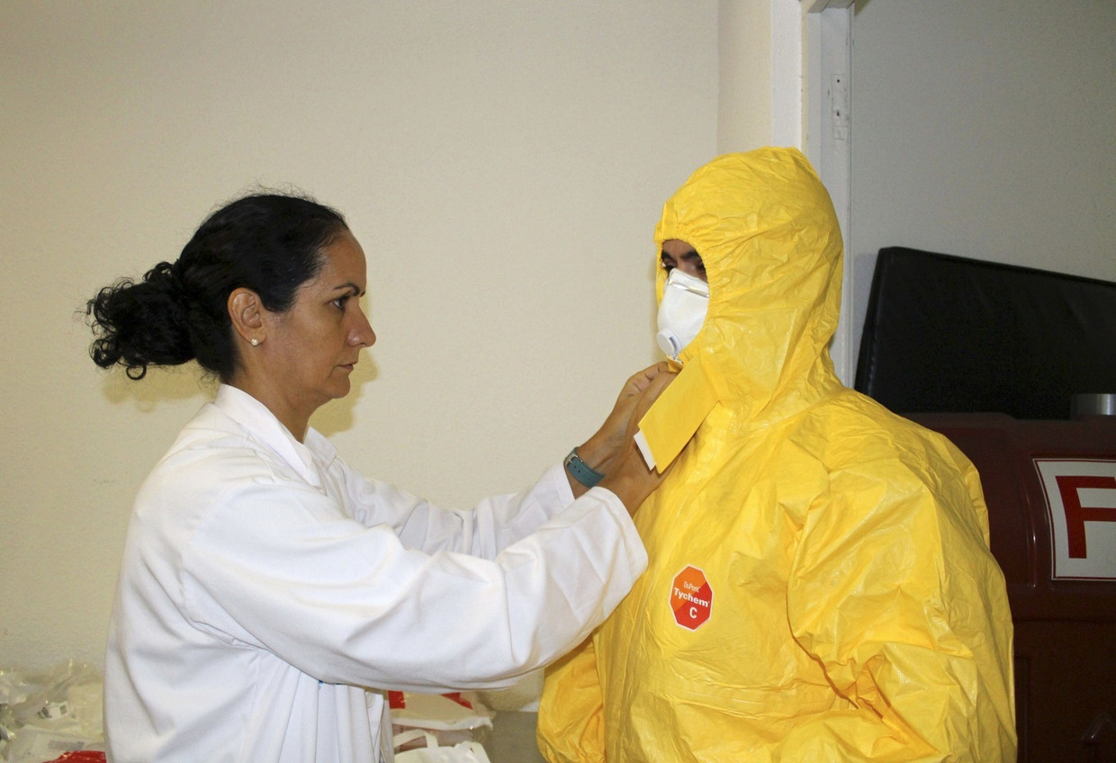 Artsen trekken beschermende kleding aan in een Spaanse ziekenhuis om een met ebola besmette patiënt te kunnen behandelen. Beeld epa