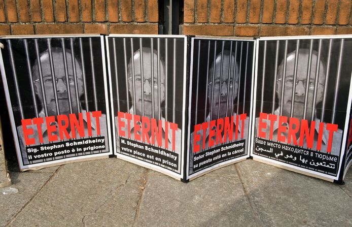 Posters met in verschillende talen de tekst 'Stephan Schmidheiny, uw plek is in de gevangenis'. Archiefbeeld uit 2012, toen de zakenman tijdens een eerste groot proces al dertien jaar cel had gekregen.
