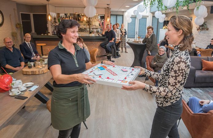 Sabine de Rooij van de Meiboom (l) ontvangt uit handen van Mirjam Vreeke van Ter Weel, de Krabbendijkse variant van Monopoly.