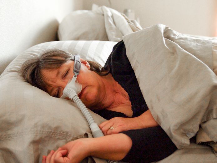 Illustratiebeeld van vrouw met slaapapeu-apparaat.