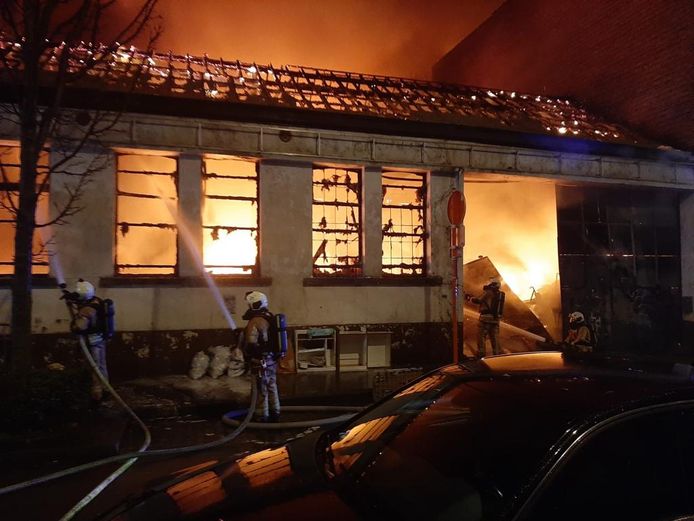 Brandweermannen proberen het vuur te doven in een opslagplaats aan de Rafaelstraat in de Brusselse gemeente Anderlecht.