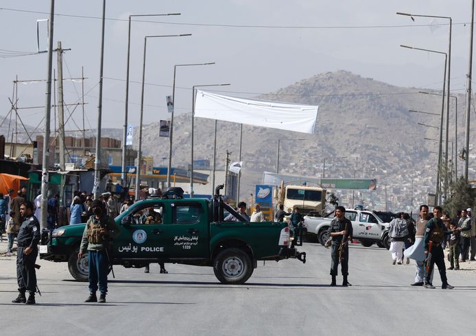 Afghaanse beveiligers bewaken een gebied waar een mijn explosie af ging bij de ingang van een stembureau.