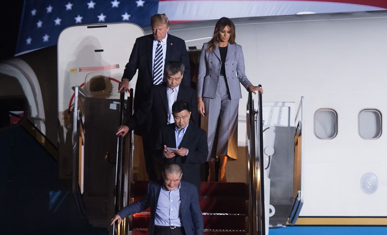Donald Trump en zijn vrouw Melania dalen de vliegtuigtrap af achter de vrijgelaten Tony Kim (bovenaan de trap), Kim Dong-chul (beneden) en Kim Hak-song (midden) Beeld AFP
