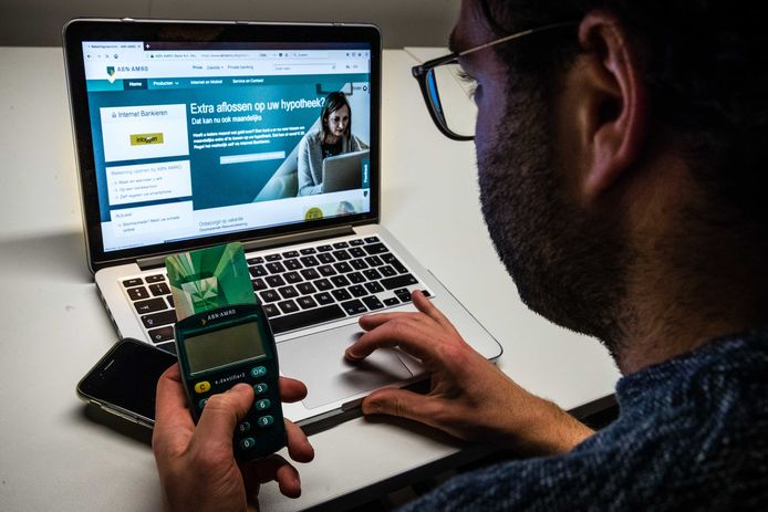 Een man aan het internetbankieren met ABN Amro. Het telebankieren van de Nederlandse bank kampte met een storing door een DDoS-aanval.