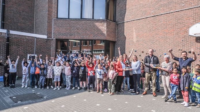 Foto van de overhandiging van de boekenpakketten donderdagnamiddag, op de speelplaats van 't Fort