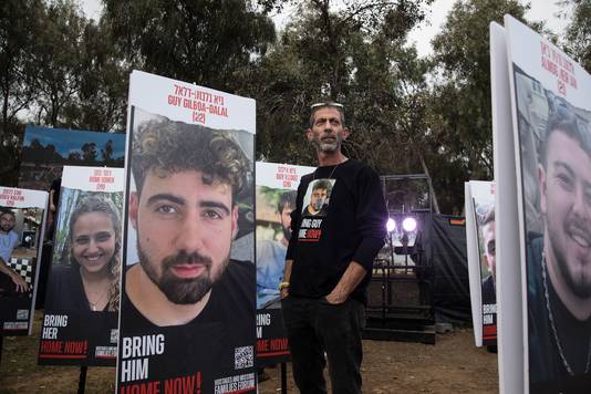 Ilan Gilboa Dalal staat naast een poster van zijn zoon Guy Gilboa Dalal, die gegijzeld werd door Hamas op het Nova festival. 