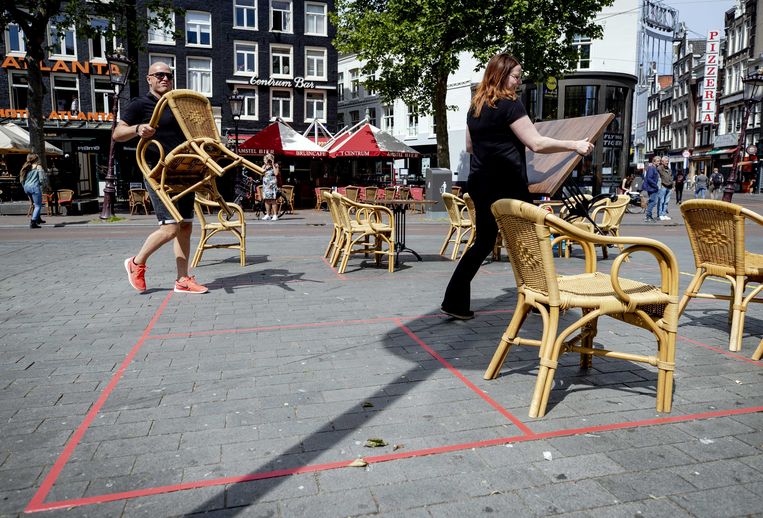 Medewerkers van een terras op het Rembrandtplein plaatsen stoelen en tafels op voldoende afstand tijdens de vorige periode met de 1,5-meterregel. Beeld ANP