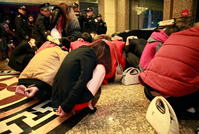 De politie pakt regelmatig prostituees op, hier in een hotel in de stad Dongguan, februari 2014.
