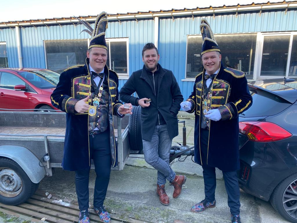 Carnavalsvereniging De Turftrappers hebben een heuse drive-in ingericht om brandhout uit te delen: luciferdoosjes. Prins Stephen (links) en adjudant Jesper nemen iemand in de maling. Het slachtoffer kan er gelukkig om lachen.