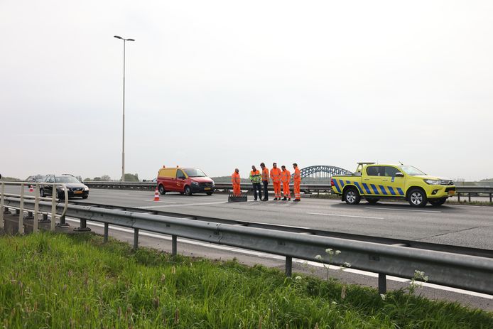 Beraadslaging van Rijkswaterstaat bij de slechte plek in het wegdek.