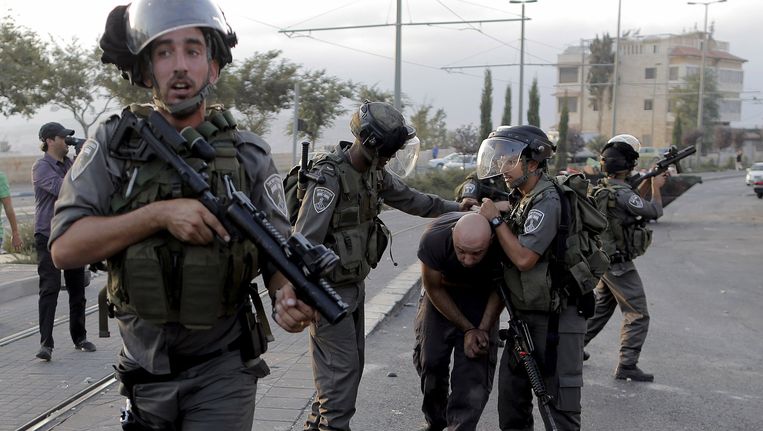 Israëlische militairen pakken een Palestijnse betoger op bij Jeruzalem Beeld REUTERS