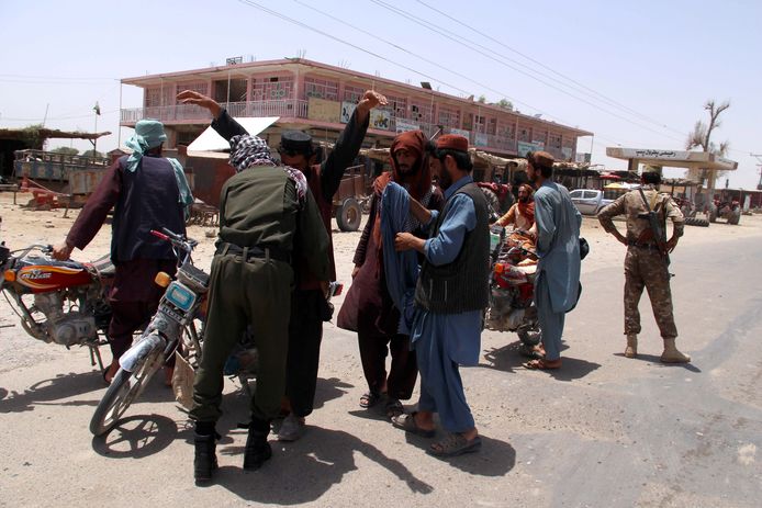 Beveiligers controleren mensen en voertuigen aan een controlepunt in de Afghaanse provincie Helmand.