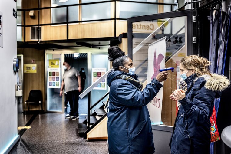 De temperatuur van een vrouw wordt gecontroleerd. 'Voorlopig weten we op basis van zijn mutaties enkel dat de omikronvariant een lastige klant dreigt te worden.' Beeld Franky Verdickt