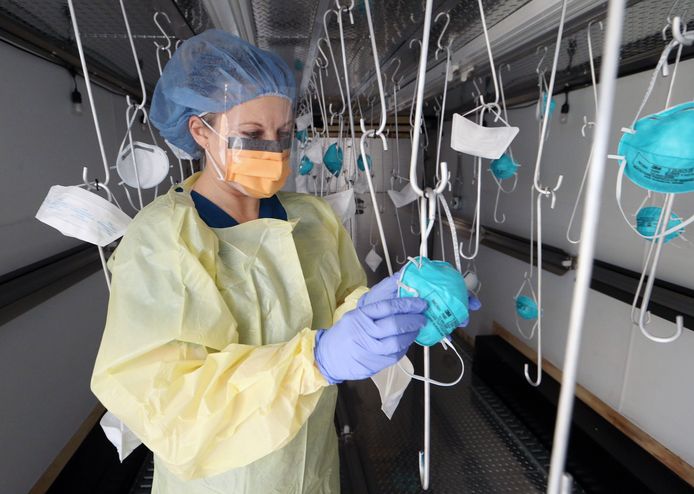 Een verpleegster inspecteert mondmaskers die met UV-licht werden gedesinfecteerd voor hergebruik in een Amerikaans ziekenhuis.