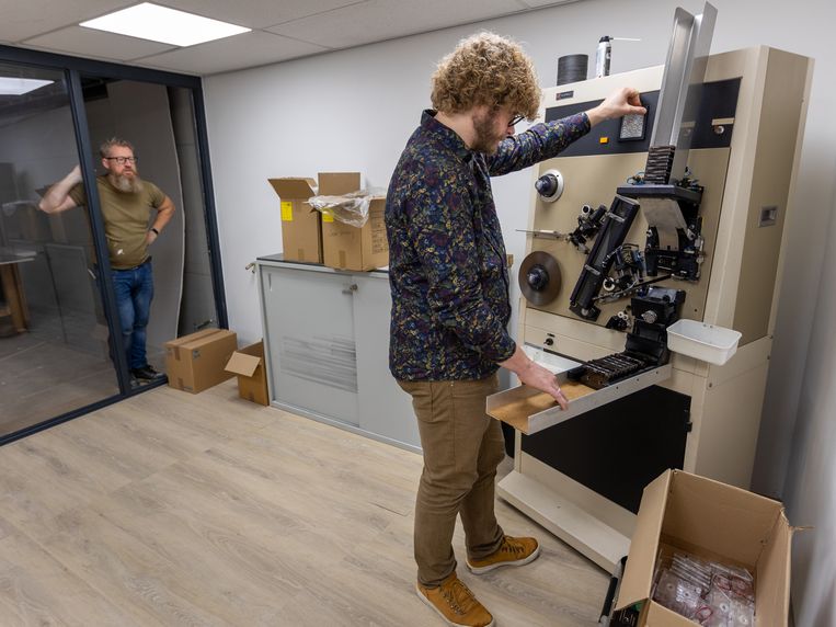 Thomas Baur (r) in zijn cassettebandjesfabriek in Lochem, bij de machine waarmee de bandjes op de juiste lengte worden gemaakt.  Beeld Herman Engbers