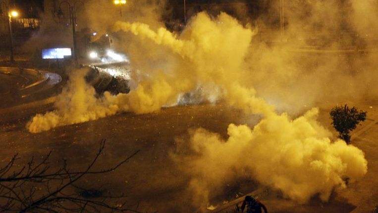 Veiligheidstroepen schieten met traangas bij een confontatie met demonstranten voor het presidentiële paleis. Beeld reuters