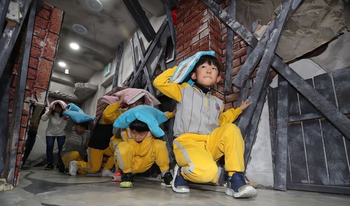 Zuid-koreaanse kinderen doen mee aan een training in Seoul, waar ze leren hoe ze moeten reageren op een aardbeving. Foto Yonhap