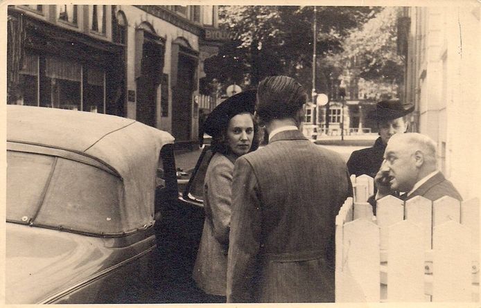 Oma en opa staan bij de voordeur van nr. 2 in de Herenstraat. De moeder van Leo en haar broer oom Hans (op de rug gezien)  wachten bij de auto. Op de achtergrond het Plein.