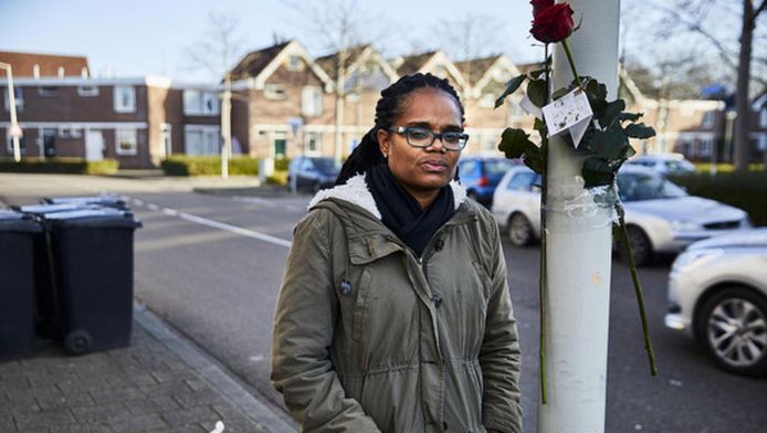 Luci Rimon in de straat op de plaats waar haar broer Shurandly en haar neefje Faichel gisteravond werden neergeschoten. Mensen hebben bloemen aan de lantaarnpaal gebonden.