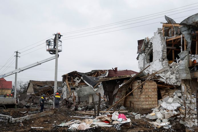 Mensen proberen de stroom te herstellen bij vernielde gebouwen vandaag in Hlevakha, buiten Kiev.