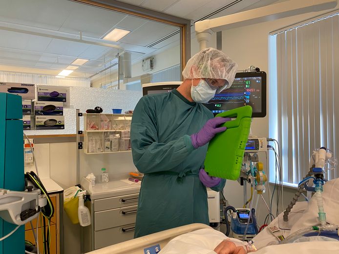 Een ic-verpleegkundige van Ziekenhuis Gelderse Vallei in Ede laat aan familieleden zien hoe het met de patiënt met corona gaat.