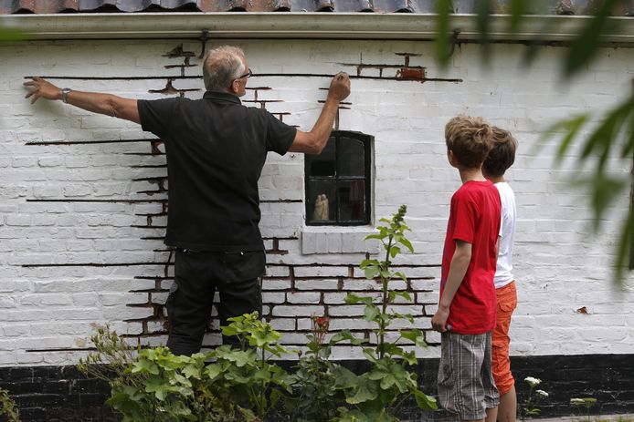 Een inwoner van Loppersum plaatst ijzeren pennen in zijn woning na een aardbeving in het noorden van de provincie Groningen.