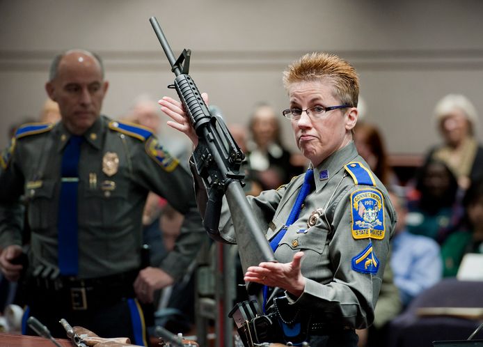 Een Amerikaanse politieagente toont een Bushmaster, eenzelfde model als de Remington ACR rifle, gebruikt door de schutter die in 2012 26 mensen doodde in een basisschool in Sandy Hook.