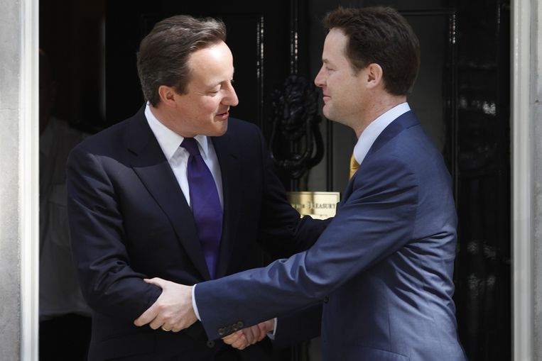 De kersverse Britse minister-president David Cameron, ontvangt zijn vicepremier Nick Clegg op Downing Street 10. (AP) Beeld 