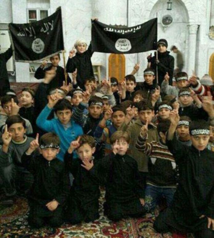 Foto uit november 2014: kinderen van Syriëstrijders poseren met vlaggen van Islamitische Staat (IS) in de Syrische stad Raqqa, toen nog de ‘hoofdstad’ van het door IS uitgeroepen ‘kalifaat’.