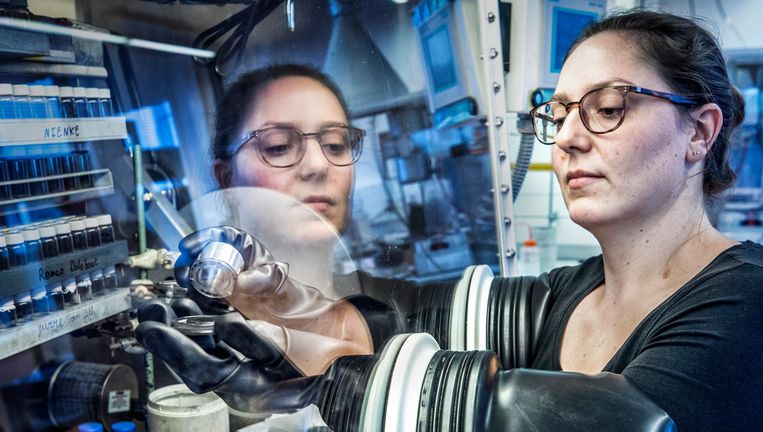 Een medewerker van de Universiteit Utrecht werkt aan accu¿s in de zogeheten handschoenenkast. Beeld Raymond Rutting/de Volkskrant