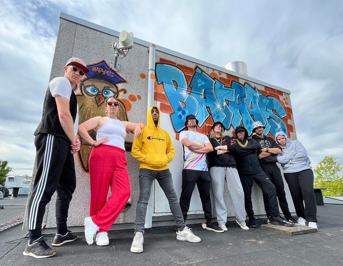 De docenten op het dak van de school bij het ketelhuis dat voor de gelegenheid werd opgesierd met graffiti. Vierde van links is locatieleider Bas Smies.