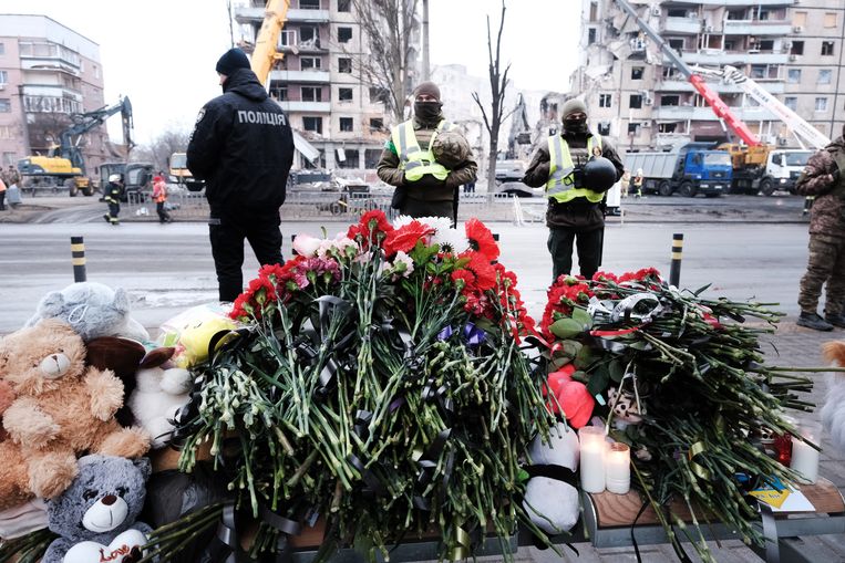 Bloemen en knuffeldiertjes worden voor het getroffen appartementsgebouw in Dnipro gelegd. Beeld Getty Images