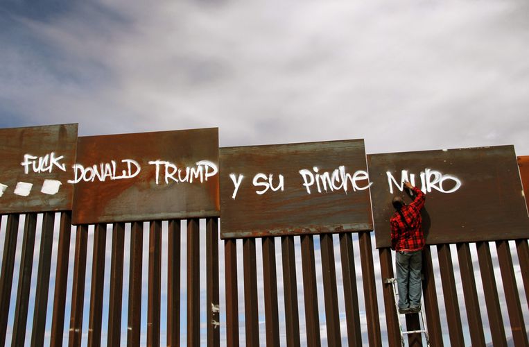 Leuzen op de muur langs  de Amerikaans-Mexicaanse grens in Ciudad Juarez in Mexico. Trump heeft ongeveer 500 kilometer van de muur gebouwd, op een totale grens van 3.200 kilometer.  Beeld AFP