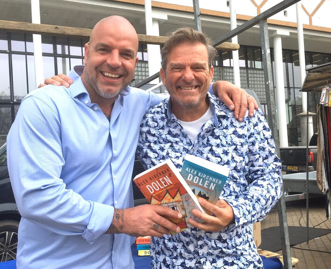 Alex Kirchner (r) vandaag voor zijn marktkraam met oud-voetbalinternational Andy van der Meijde. ,,Hij heeft beide delen al gelezen.''