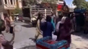 Een talibanstrijder slaat snoeihard met een stok op een van de protesterende vrouwen.