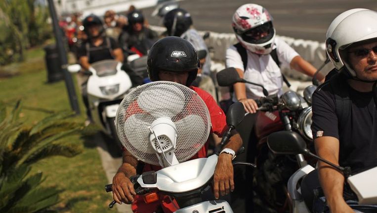 Bromfietsers en motorrijders wachten in kilometrslange rijen om de grens bij Gibraltar over te steken Beeld REUTERS