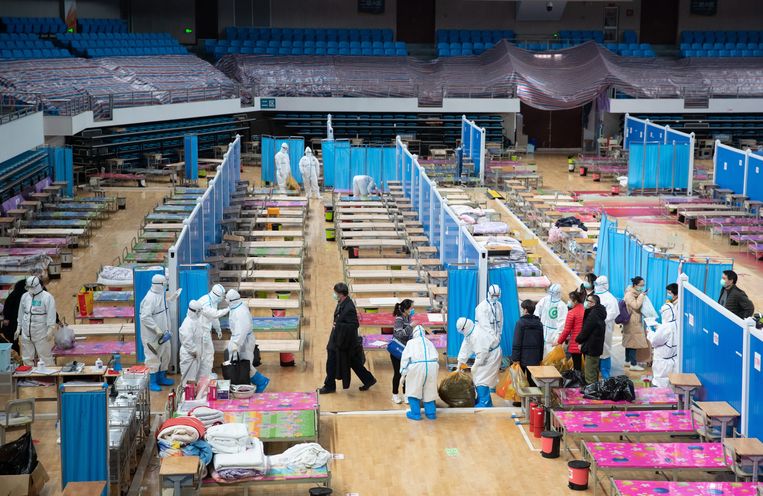 Medewerkers ruimen het noodhospitaal in de sporthal van Wuchang op.   Beeld EPA