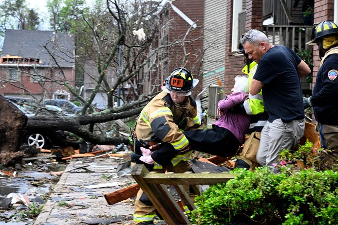 Een vrouw wordt haar woning uitgedragen na doortocht van de tornado in Little Rock, Arkansas.