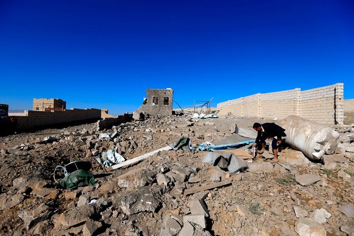 Een man zoekt tussen de resten van een gebouw dat kapotgeschoten is door de Saudiërs in de Jemenitische hoofdstad Sanaa.