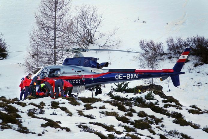 Een Oostenrijkse politiehelikopter bij een slachtoffer naast de piste.