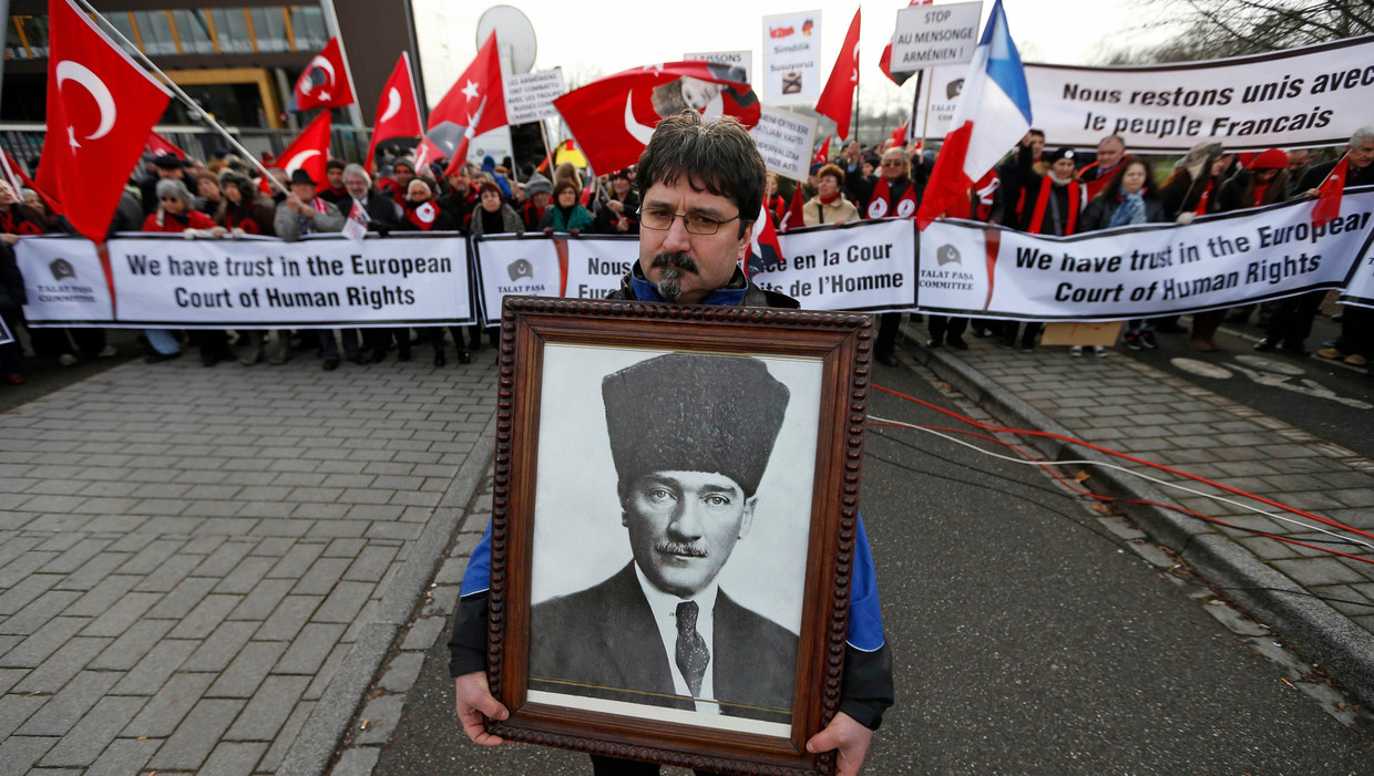 Een Turkse man staat met een portret van Ataturk bij een demonstratie in Straatsburg. Beeld REUTERS