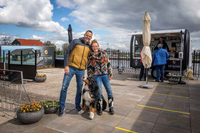Andre de Jong en Mirjam Lammerse met hond Bo, voor hun foodtruck. Op de achtergrond een impressie van Brasserie De Schie.
