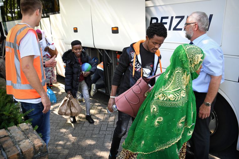 Asielzoekers worden vanuit een sporthal in Loon op Zand naar Maashorst gebracht. Omdat het aanmeldcentrum in Ter Apel vol zit worden vluchtelingen van hot naar her gestuurd. Beeld Marcel van den Bergh