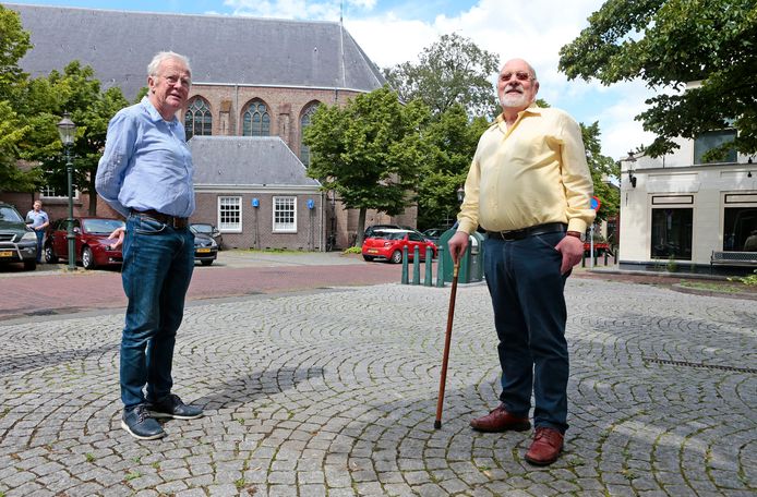 Cees van Zelderen (rechts) en Leendert Spijker zijn bang dat nieuwbouw op de plek van het witte huisje rechts hoger wordt dan de nok van het kerkdak.