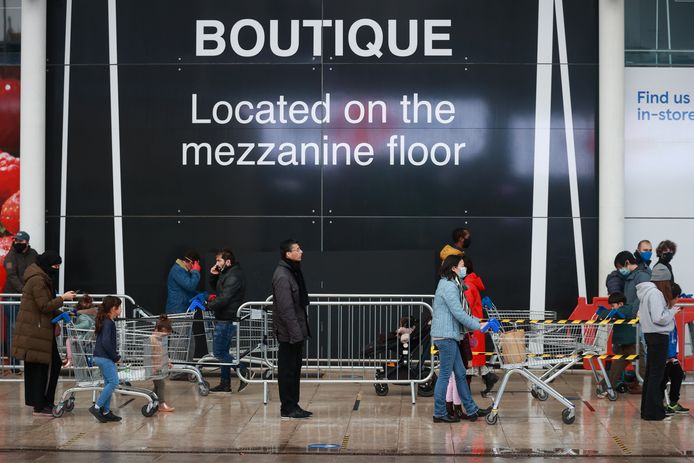 Les gens font la queue devant un magasin Tesco alors que de nouvelles restrictions sont entrées en vigueur, à Londres, en Grande-Bretagne.