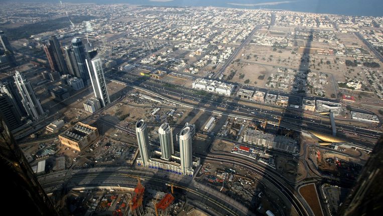 De schaduw van de Burj Dubai toren valt over de stad. In het Midden Oosten lijken de bomen soms tot aan de hemel te groeien. Beeld AFP
