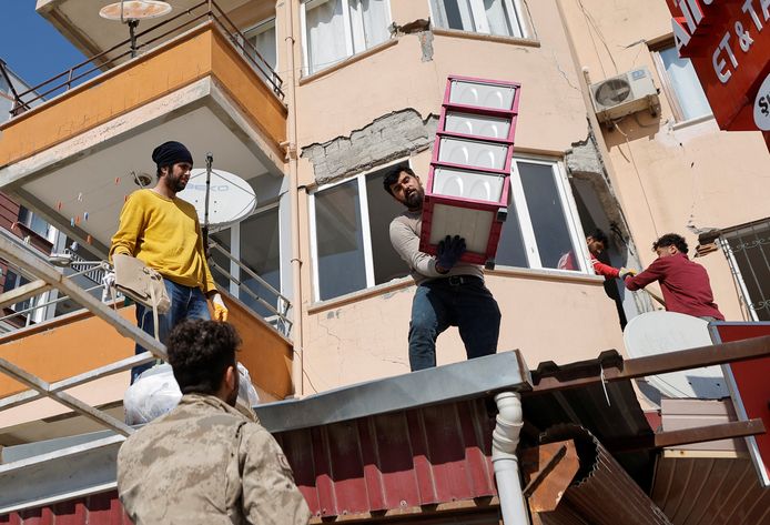 Mensen halen spullen op uit hun appartementen in Antakya.