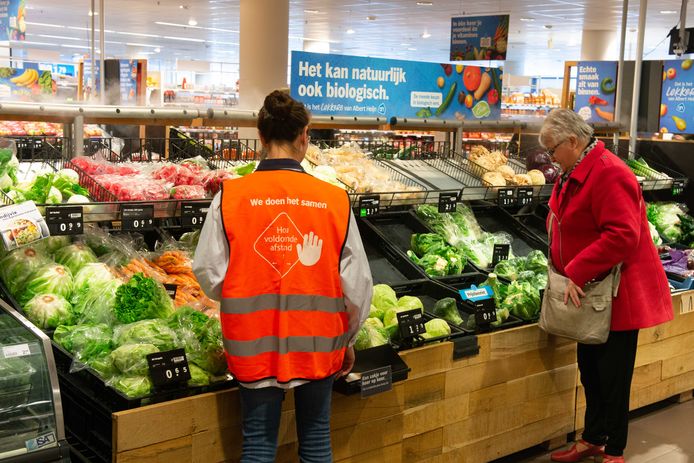 De vakkenvullers van de supermarkten krijgen speciale hesjes met een duidelijke tekst op de achterkant: ‘hou voldoende afstand.’
