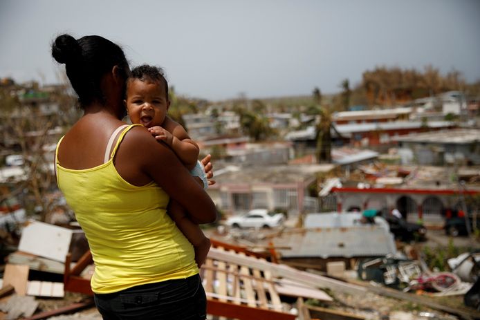 Een vrouw kijkt uit over haar verwoeste buurt na de doortocht van orkaan Maria in Puerto Rico in september 2017.