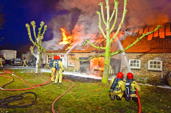 Brandweerlieden in actie bij een brand in een woonboerderij in Riethoven.